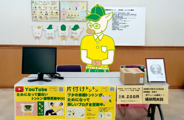 片付けトントンのブースの写真と、受付をするトン二郎のイラスト