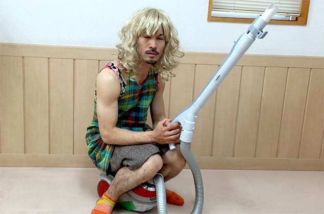 先端にトイレットペーパーの芯をつけた掃除機の上に、お母さん(トン太)が乗っているところの写真の写真