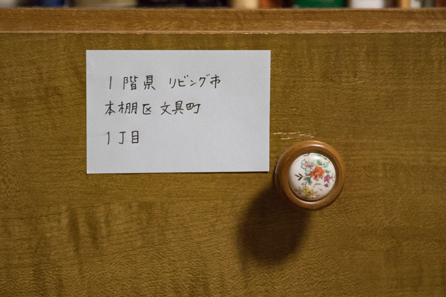 「1階県 リビング市 本棚区 文具町1丁目」というシールを張った引き出しの写真