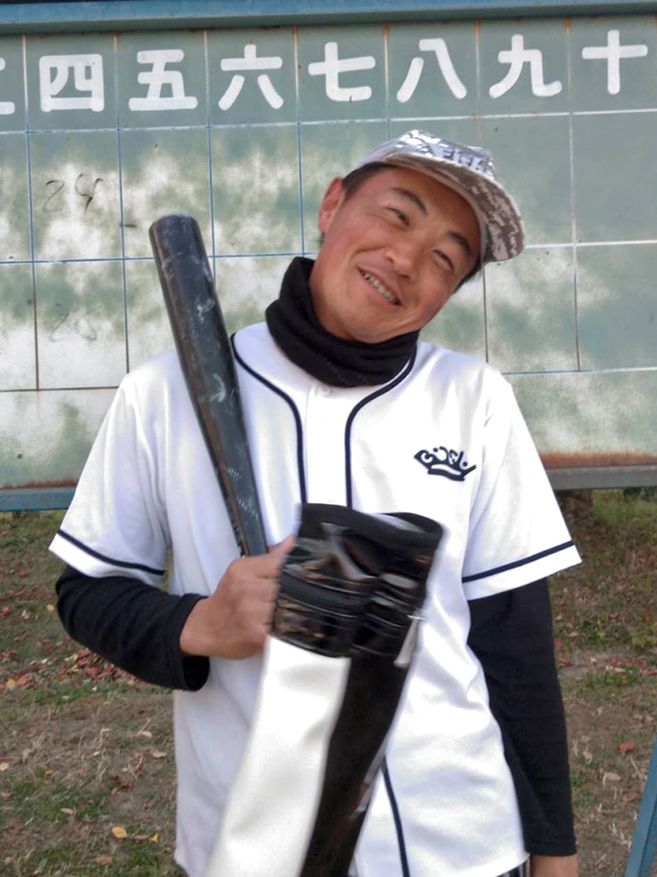野球のユニフォームを着てバットを持つ高橋の写真