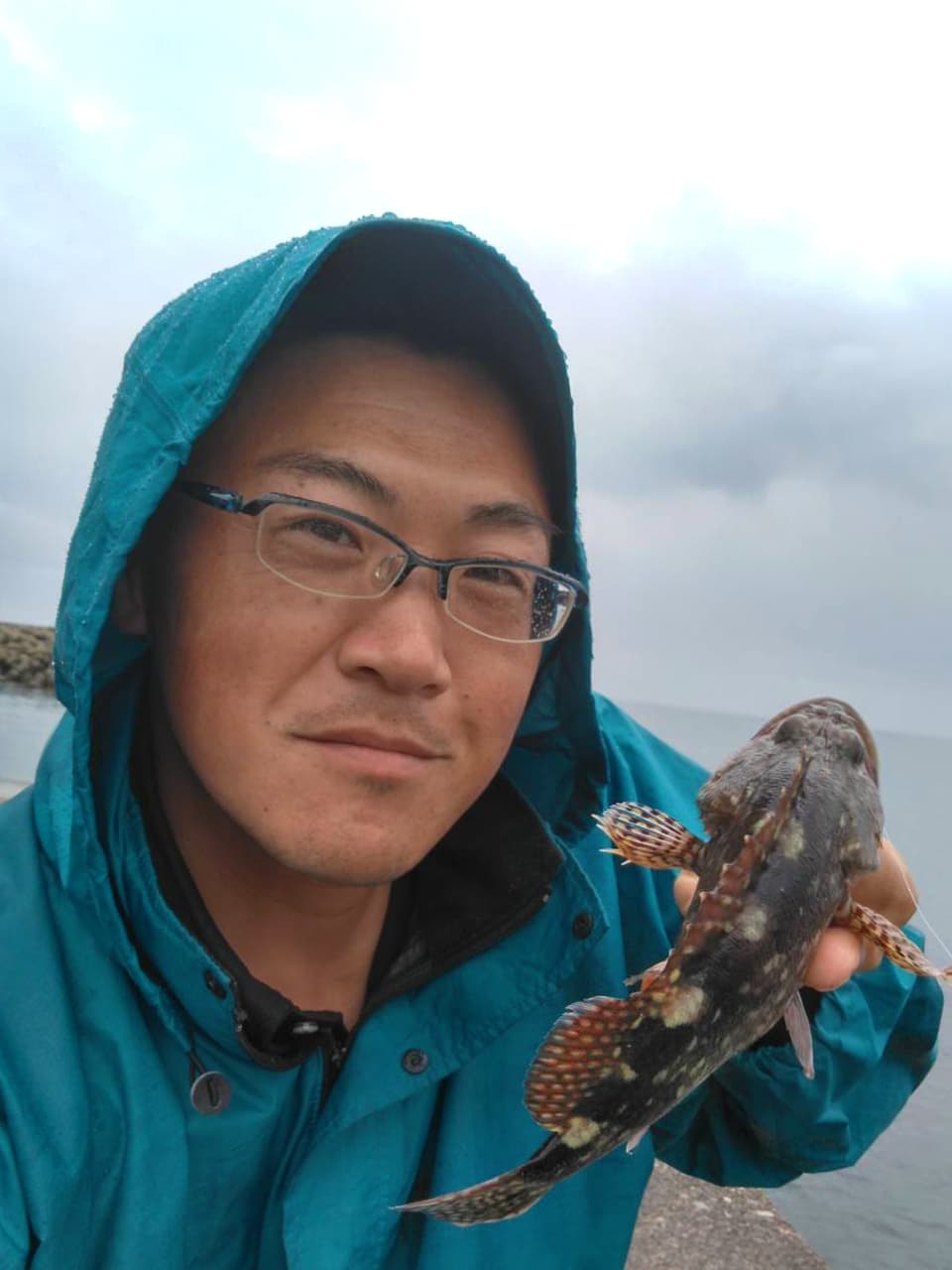 釣った魚を持つ高橋の写真
