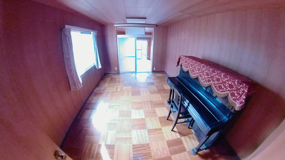 「ゴミ屋敷になってしまった実家の片付け」ピアノのある洋室のアフター写真（ピアノ以外のモノが全て無くなり、部屋の奥まで見渡せる）