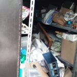 ガレージ内の棚に書類や不用品が詰まっている様子（作業前）