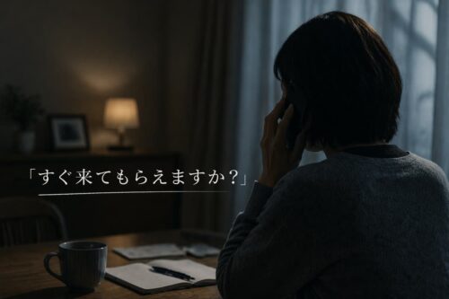 夜、自宅で電話をかける女性。遺品整理の急ぎ相談をイメージした写真