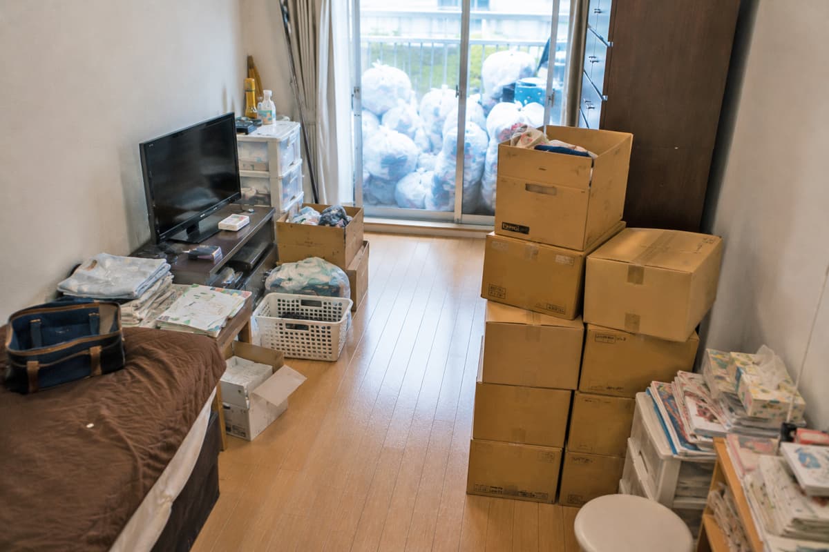 引越し前の1Rの部屋で、床が見え始め、ダンボールや可燃ごみをまとめた途中経過の様子