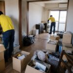 引越し後の住まいで不用品を仕分けしながら片付ける作業員